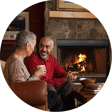 A couple relaxing beside a warm fireplace