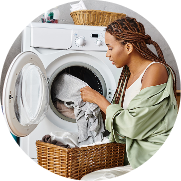 A woman loading laundry into a dryer