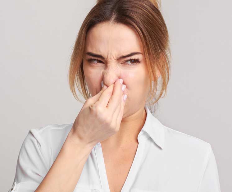 Woman pinching her nose shut